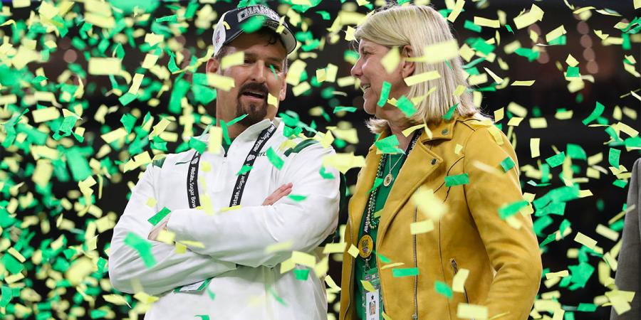 Mack Rhoades and Linda Livingstone amidst falling green and gold confetti