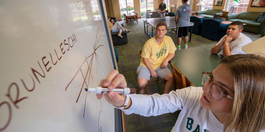 Baylor students studying together on campus while others play table tennis together in the background