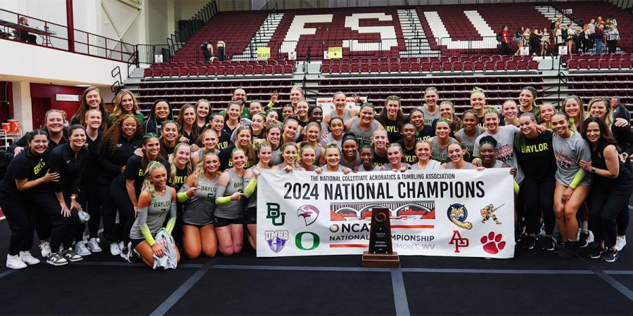 Baylor Acrobatics & Tumbling team poses with the national champions banner and trophy