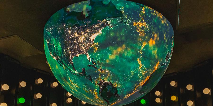Green and gold globe hanging in a Hurd Welcome Center column