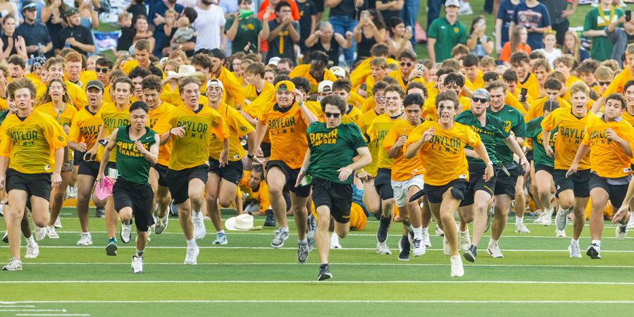 Baylor Line students running on the field at McLane Stadium