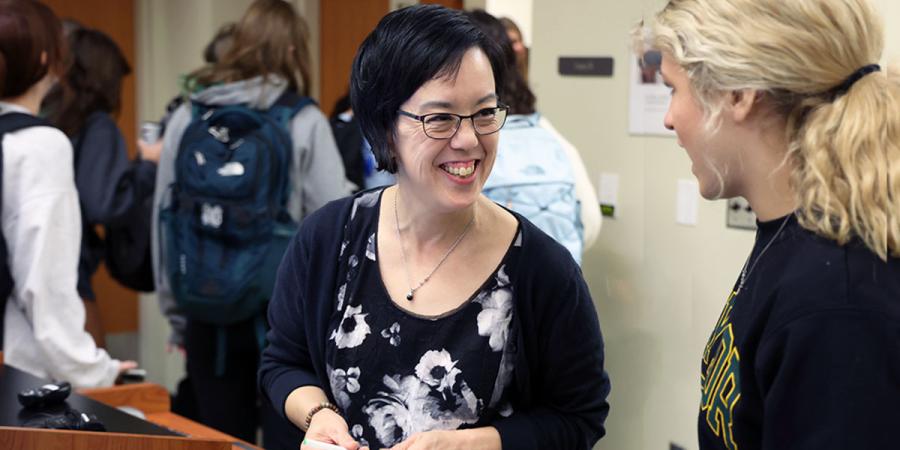 Dr. Jo-Ann Tsang speaking with a student