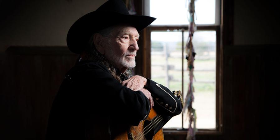 Willie Nelson poses with his guitar