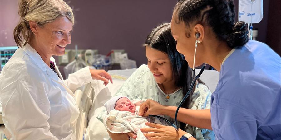 Medical staff attend a new mother and child in a hospital