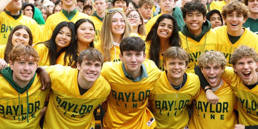 Baylor students pose together in their Line jerseys at a football game